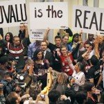 Grupo de manifestantes levanta cartazes - Tuvalu is the Real Deal