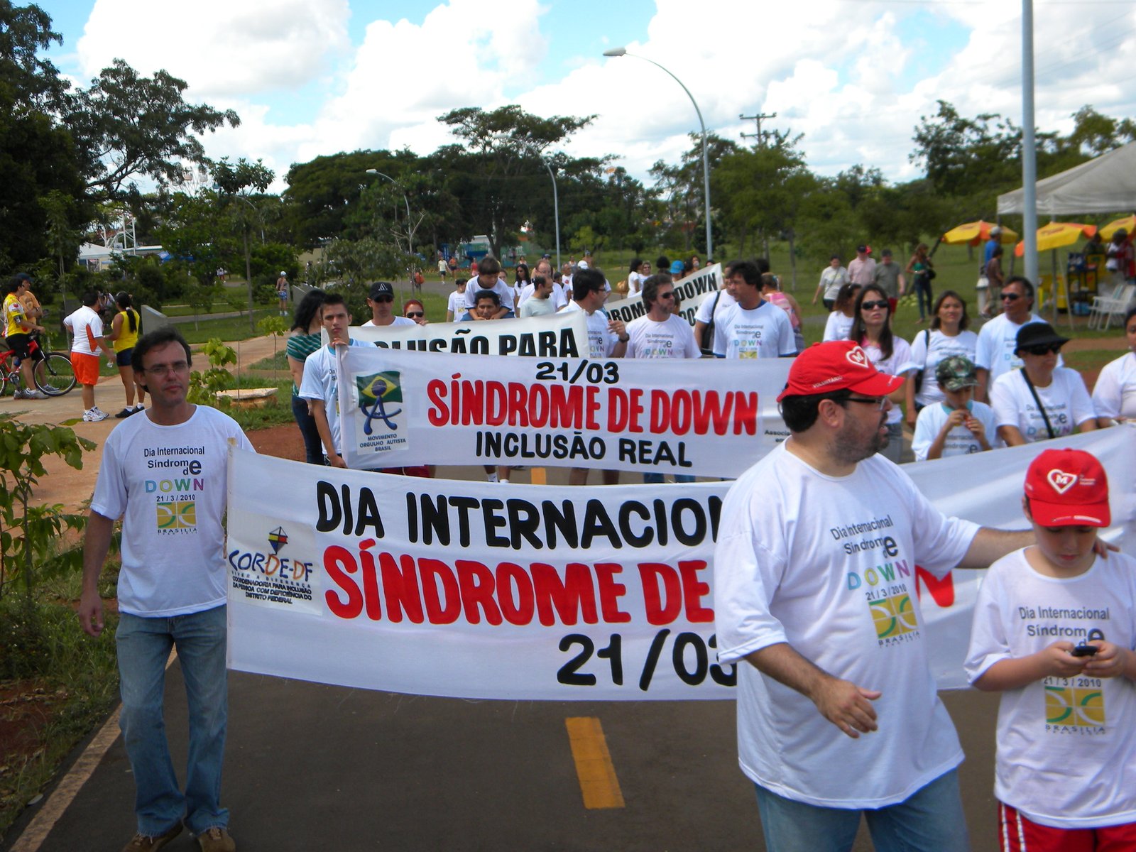 Participantes exibem faixas comemorativas do Dia Internacional da Síndrome de Down durante caminhada