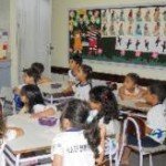 sala de aula Crianças por volta de 7 anos sentadas em mesas em grupos de 4 em sala de aula