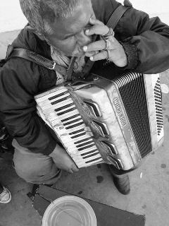 Artista de rua cego, tocando acordeon