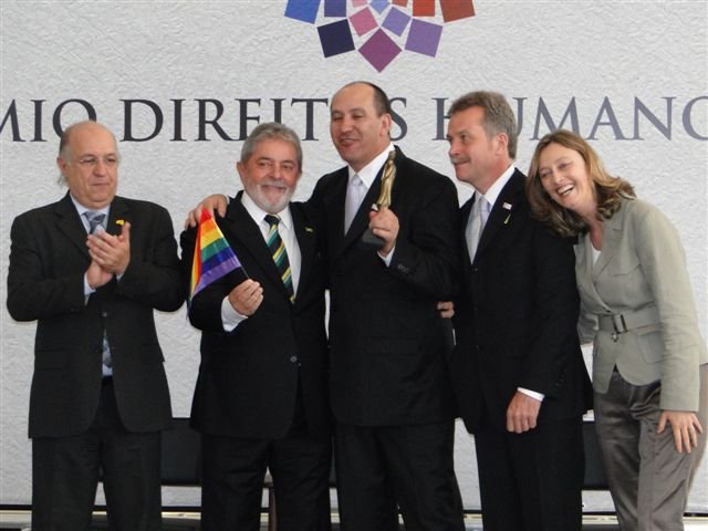 Toni Reis recebe o troféu e o Presidente Lula segura um mini-bandeira do movimento LGBT, ao lado do Ministro Paulo Vanucchi, do Ministro Juca Ferreira e da futura Ministra Maria do Rosário.