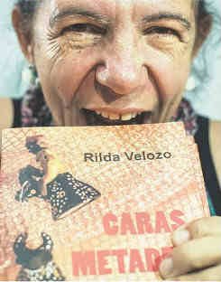 Rilda finge morder com a boca aberta o seu livro "Caras Metades"