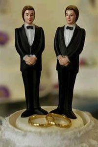 Casamento gay - dois bonecos no topo de um bolo de casamento e duas alianças Casamento gay - dois bonecos no topo de um bolo de casamento e duas alianças