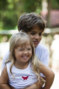 Menino e menina abraçados, sorrindo.