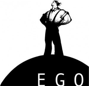 Desenho em preto e branco de homem forte de pe em um monte onde esta escrita a palavra EGO.