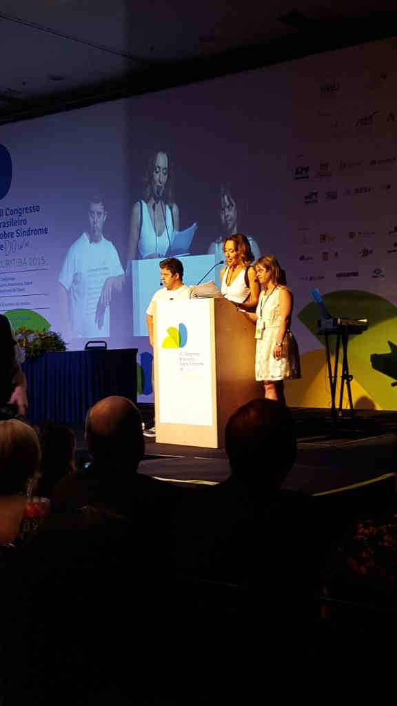 Fernanda e Breno no palco de abertura, ao lado da cerimonialista.