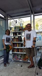 um homem e uma mulher, estante de livros em ponto de onibus. 