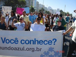 Grupo de manifestantes a pé e em cadeira de rodas. na faixa da frente, Você Conhece? mundoazul.org.br