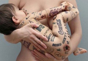 Publicidade infantil - um bebê sendo amamentado, seu corpo está carimbado com dezenas de marcas comerciais Publicidade infantil - um bebê sendo amamentado, seu corpo está carimbado com dezenas de marcas comerciais