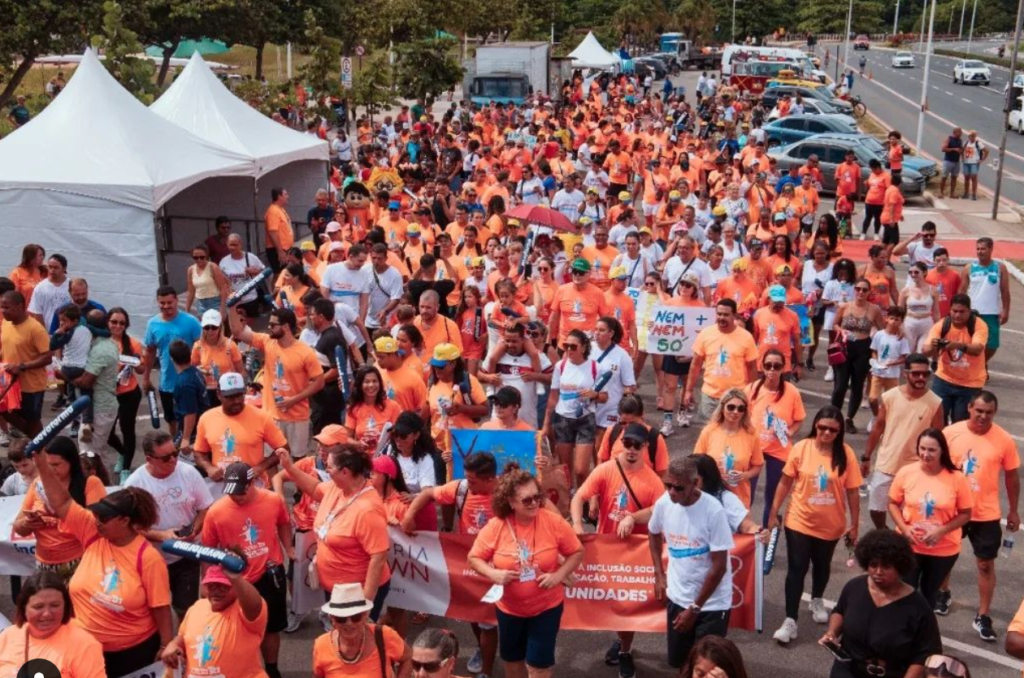 centenas de pessoas com camisetas laranja na caminhada do Vitória Down.