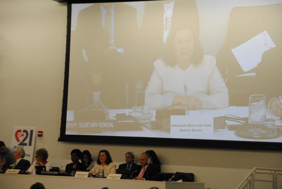 Mulher sentada à bancade de auditório, no telão aparece sua imagem e o nome Ambassador Maria Luiza Viotti, Brazilian Mission.