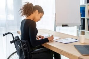 mulher em cadeira de rodas em frente a computador