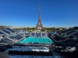 Foto aberta da arena de competição do futebol de cegos em Paris 2024 e, ao fundo, a Torre Eiffel.