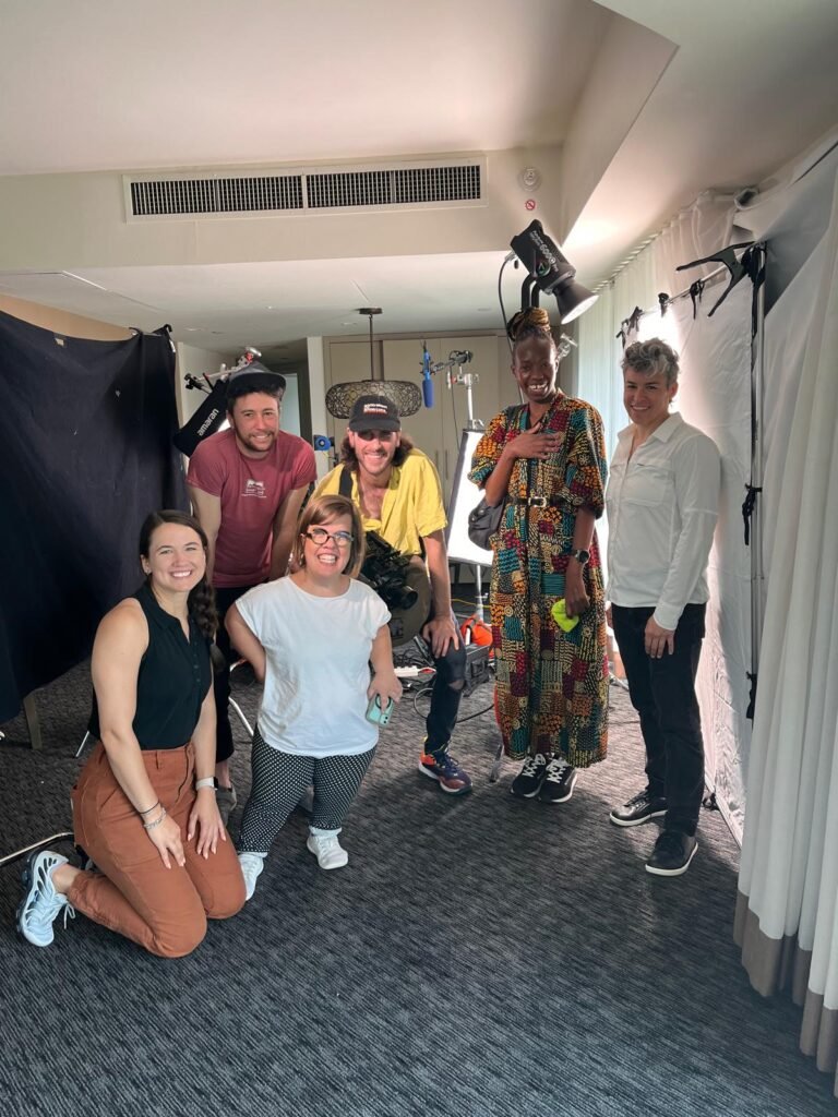 Equipe de filmagem e pessoas com diferentes deficiências reunidas.