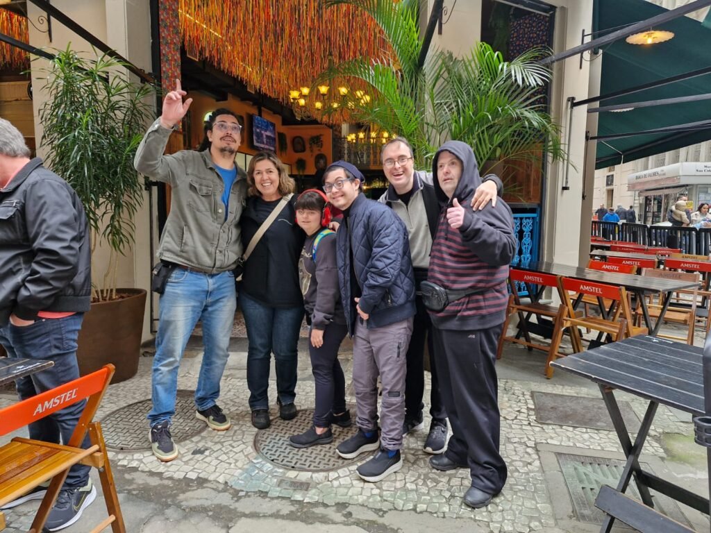 grupo de 4 homens e uma mulher em frente a restaurante.