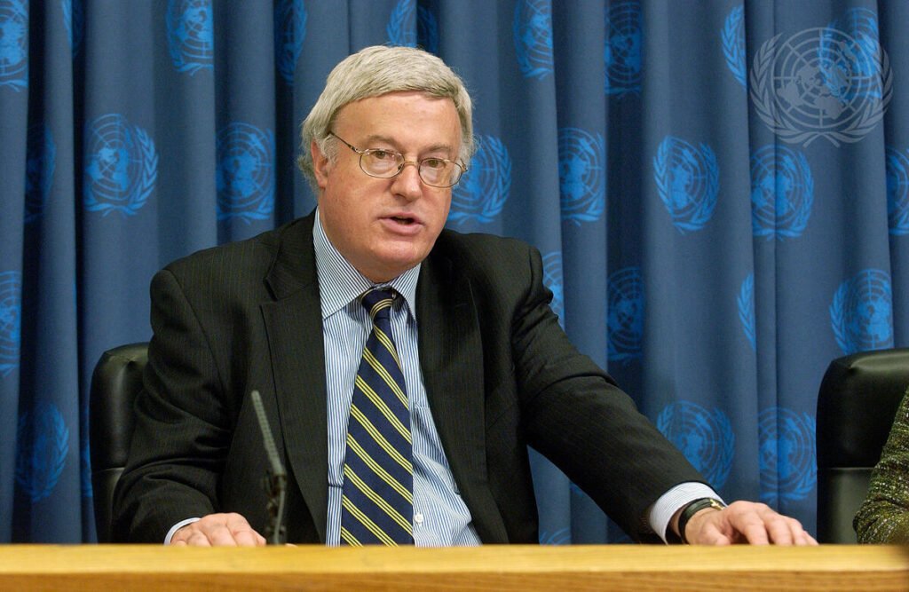 don mackay falando sentado na onu.
