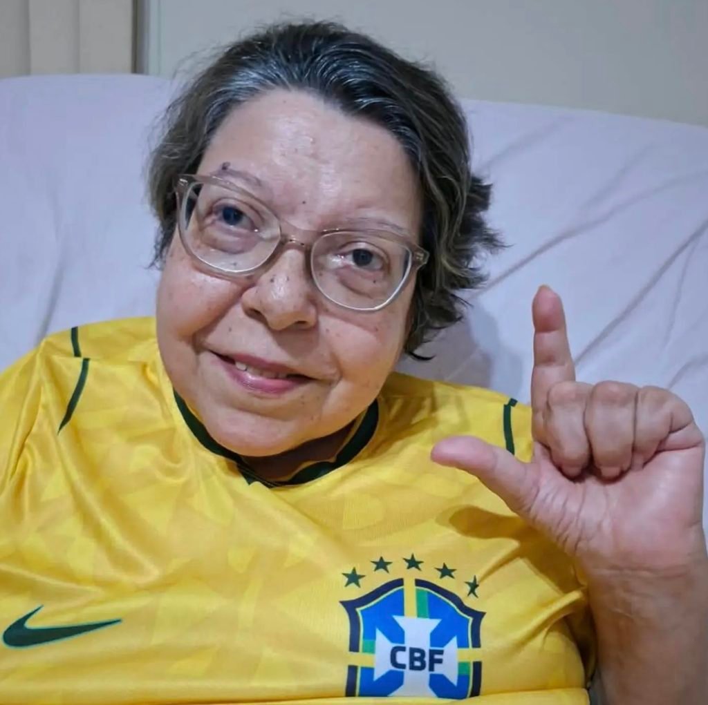 Izabel Maior com a camiseta da seleção brasileira fazendo o L.