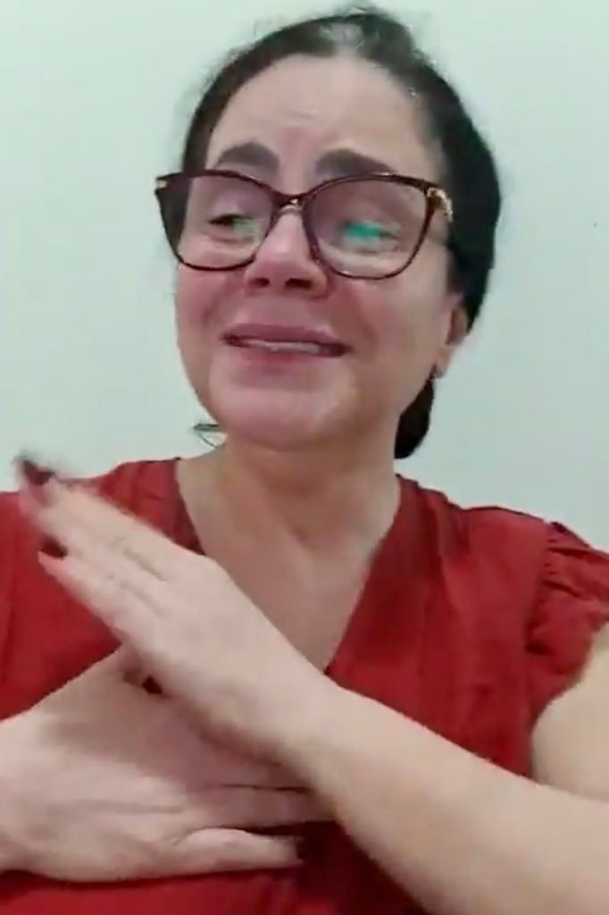Patricia Rezende com blusa vermelha sinalisa.